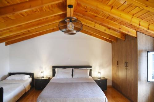 two beds in a bedroom with wooden ceilings at The country house in Paramonas