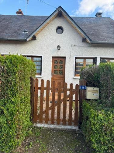 une clôture en bois devant une maison blanche dans l'établissement Shelby house, à Prémery