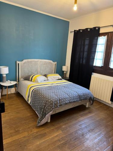 une chambre avec un lit et un mur bleu dans l'établissement Shelby house, à Prémery