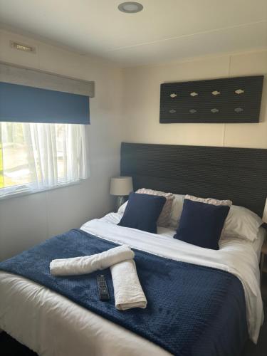 a bedroom with a large bed with two towels on it at The Wardens Hideaway - Tattershall Lakes Country Park in Tattershall