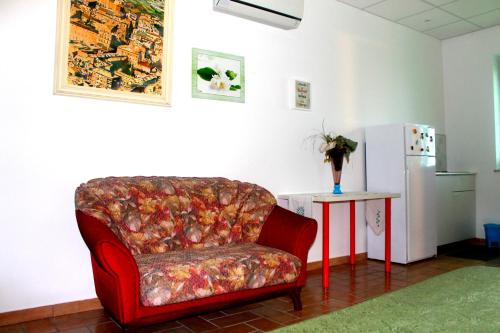 ein Wohnzimmer mit einem roten Stuhl und einem Tisch in der Unterkunft B&B Angel's in Canosa Sannita