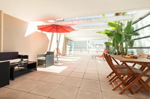 - un salon avec une table et un parasol dans l'établissement Sweet Massilia - Wifi - Host Provence, à Marseille