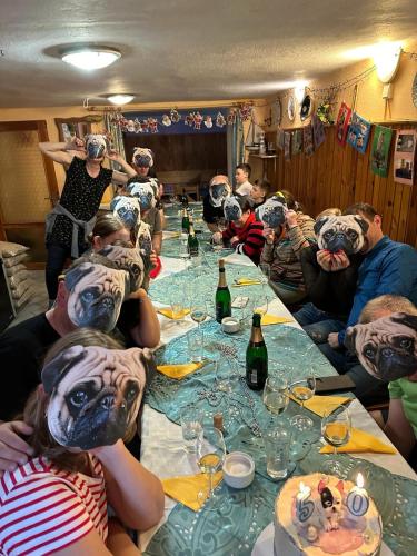 a group of people wearing masks at a long table at Horská chata LADA in Loučná pod Klínovcem