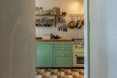 eine Küche mit grünen Schränken und einem Herd in der Unterkunft La Belle France - Maison, Parking, à 200m du Cher in Saint-Georges-sur-Cher