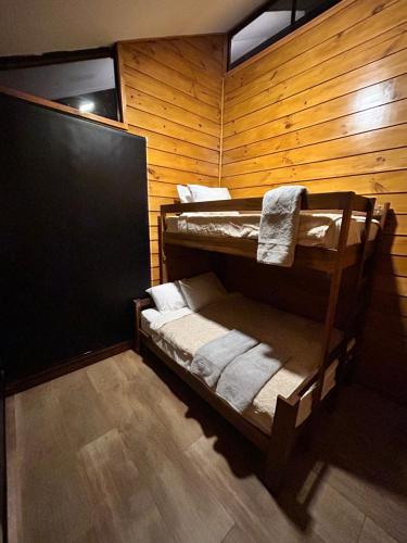 a room with two bunk beds in a wooden wall at Eco Casa Mango Lepanto #9 in Lepanto