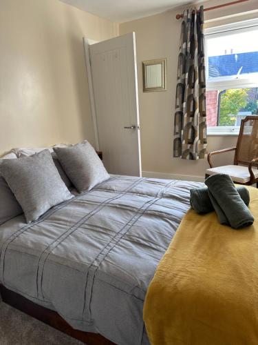 a bedroom with a bed and a chair and a window at Beautiful, cosy, comfortable Marden! in Midhurst