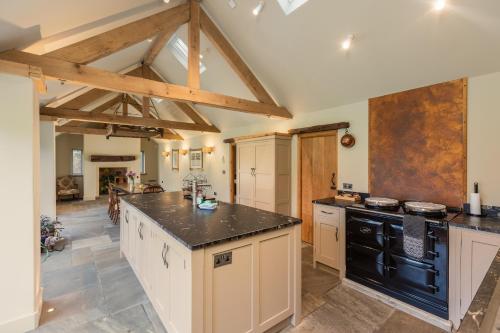 a large kitchen with black appliances and wooden beams at Scugdale Cottage - Hartoft in Pickering