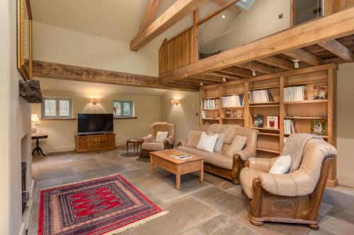 a living room with couches and a tv at Scugdale Cottage - Hartoft in Pickering
