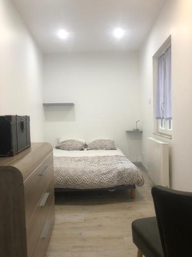 une chambre avec un lit dans une pièce blanche dans l'établissement Le onze, à Lons-le-Saunier