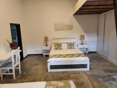 a bedroom with a bed and two tables and a desk at Casa El Encanto in Curití