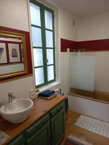 La salle de bains est pourvue d'un lavabo, d'une fenêtre et d'une baignoire. dans l'établissement Les Coustous, à Bagnères-de-Bigorre