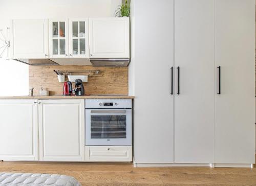 Apartment Mona في بالانغا: مطبخ أبيض بخزائن بيضاء وفرن
