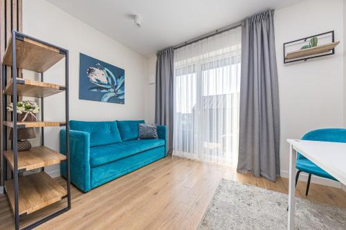 un soggiorno con un divano blu e una finestra di Apartment Mona a Palanga