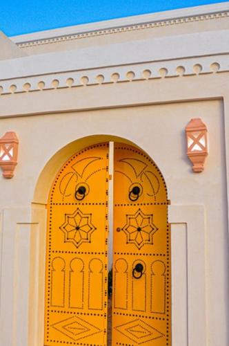 a yellow door on a white building at Dar el Ànbar in Midoun