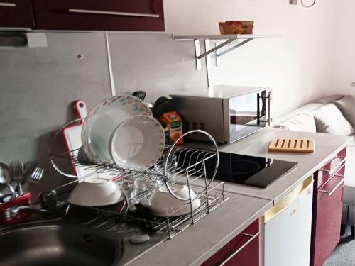 - un comptoir de cuisine avec un étendoir sur la cuisinière dans l'établissement Studio 18 m2 tout confort 4pers location semaine du samedi au samedi au pied des pistes, à Valfréjus