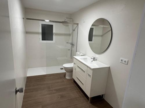 a white bathroom with a toilet and a mirror at Casa Cristea Barranda in Caravaca de la Cruz