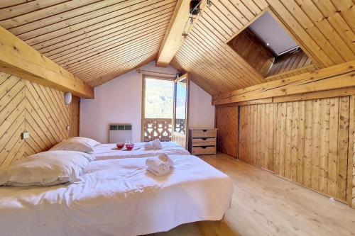 a bedroom with a large bed in a room with wooden ceilings at Chalet Les Lutins - Un cocon élégant au cœur des Allues MAE-4864 in Les Allues