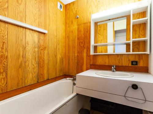 une salle de bain avec un lavabo, une baignoire et un miroir dans l'établissement Résidence Arpasson - ARPASSON 46 MAE-4521, à Les Allues