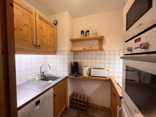 une petite cuisine avec un évier et un micro-ondes dans l'établissement Résidence Gebroulaz - GEBROULAZ 02 MAE-4581, à Les Allues