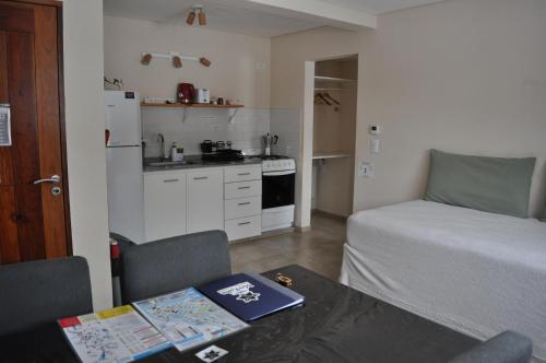 a room with a bed and a kitchen with a table at Aparts Merkaba in El Chalten
