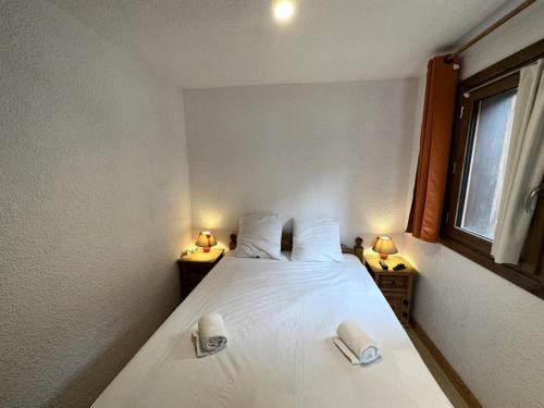 - une chambre avec un lit blanc et 2 lampes dans l'établissement Résidence Petaru - Appartement spacieux, dans le centre de la station MAE-5114, à Les Allues