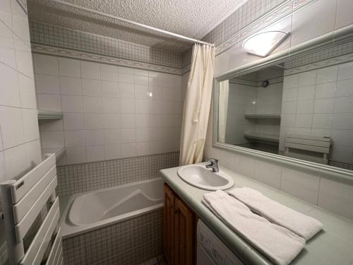 une salle de bain avec un lavabo, une baignoire et un miroir dans l'établissement Résidence Petaru - Appartement spacieux, dans le centre de la station MAE-5114, à Les Allues