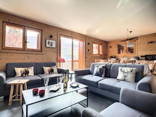 un salon avec deux canapés et une table dans l'établissement Résidence Ch. Col De La Lune - Grand chalet avec terrasse et jacuzzi MAE-4544, à Les Allues