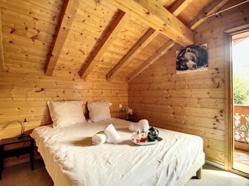 a bedroom with a bed in a wooden room at Résidence Ch. Col De La Lune - Grand chalet avec terrasse et jacuzzi MAE-4544 in Les Allues