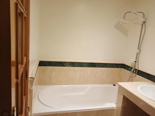 a bathroom with a bath tub and a sink at Family Apartment with Pool in Marrakech