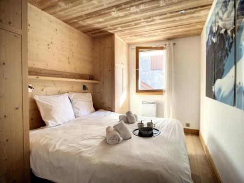 une chambre avec un lit blanc avec des serviettes dessus dans l'établissement Résidence Genevrier - Charmant apt, proche du centre et pistes MAE-7624, à Les Allues