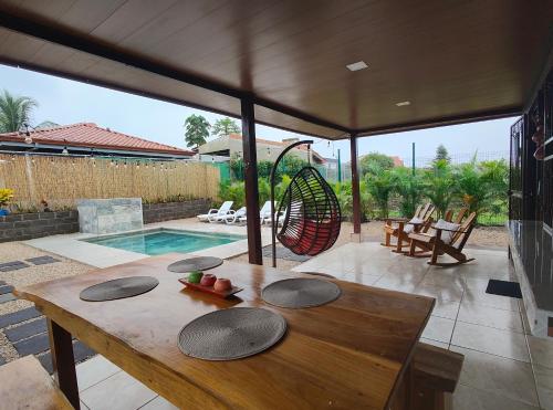 patio con tavolo in legno e piscina di Ohana Home - The Perfect Getaway! a Fortuna