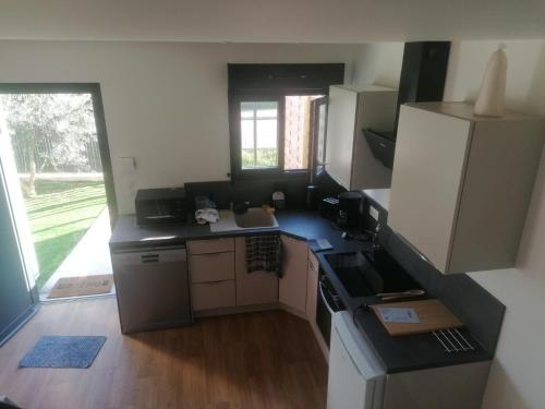 une petite cuisine avec un évier et un réfrigérateur dans l'établissement Charmant appartement de village, à Aniane