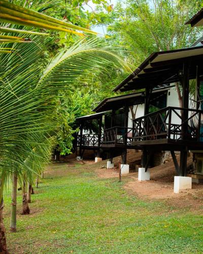 a building with a palm tree in front of it at Hacienda Don Vicente Bungalows-Tarapoto in Tarapoto