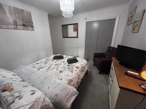 a bedroom with a bed and a desk with a television at Park House in Leicester
