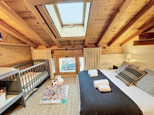 ein Schlafzimmer mit einem großen Bett und einem Dachfenster in der Unterkunft Chalet Furz'a - Chalet Familial Cosy à Méribel MAE-7811 in Les Allues