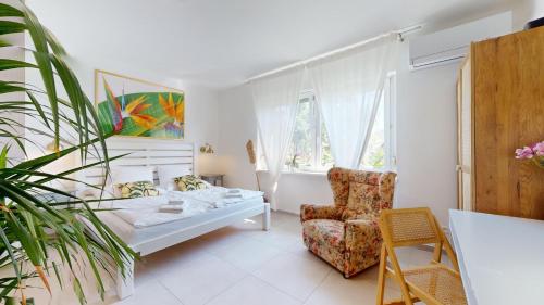a bedroom with a bed and a chair and a window at Ron De Mar - FLAMINGO in Pezinok