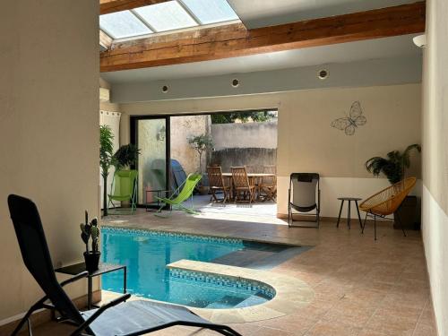 - un salon avec une piscine, une table et des chaises dans l'établissement La maison de Lalie, à Lagrasse