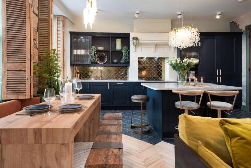 a kitchen with blue cabinets and a wooden island with bar stools at The View, luxury apartment in Berwick-Upon-Tweed