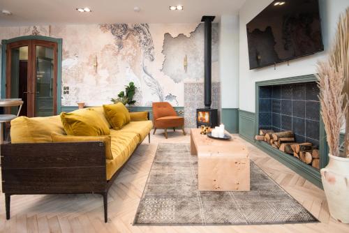a living room with a yellow couch and a fireplace at The View, luxury apartment in Berwick-Upon-Tweed