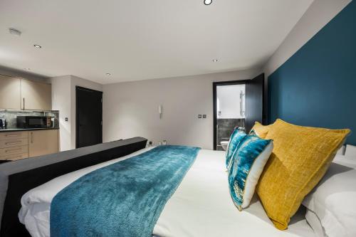 a bedroom with a large bed with blue and yellow pillows at Central Luxe - Brighton Central - 2 Beds in Brighton & Hove