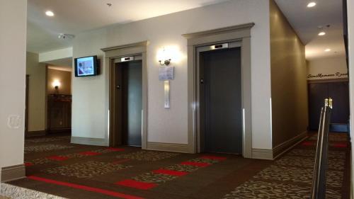 a hallway with a door and a large mirror at Royal Anne Hotel in Kelowna