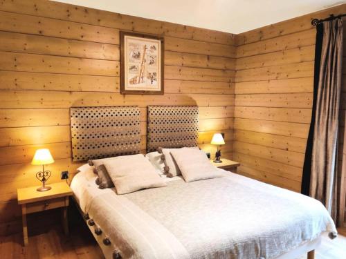 - une chambre avec des murs en bois et un lit avec deux lampes dans l'établissement Les Chalets Du Gypse - LES CHALETS DU GYPSE A06 MAE-3891, à Saint-Martin-de-Belleville