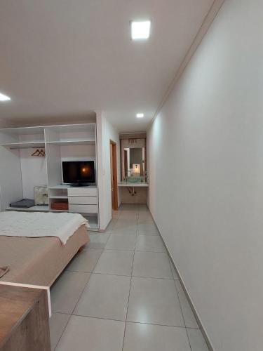 a white room with a bed and a tv at Jazmin de Lluvia in Vistalba