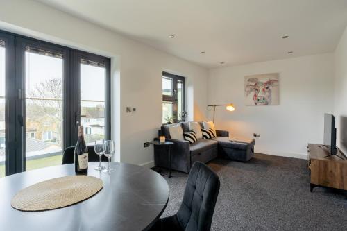 a living room with a table and a couch at Modern 2-Bed Apartment with Balcony, Close To Oxford City Centre With Free Parking in Oxford