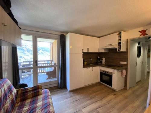 Cette chambre comprend une cuisine équipée d'une cuisinière et une fenêtre. dans l'établissement Résidence Apheratz - Magnifique studio cosy sur les hauteurs de la station des Deux Alpes MAE-3771, à Vénosc
