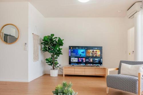 a living room with a tv and a chair at Stay Seaside Market St 116 in Woolgoolga