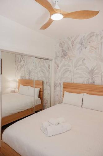 a bedroom with two beds and a ceiling fan at Stay Seaside Market St 116 in Woolgoolga
