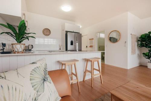 a living room with a couch and a kitchen at Stay Seaside Market St 116 in Woolgoolga