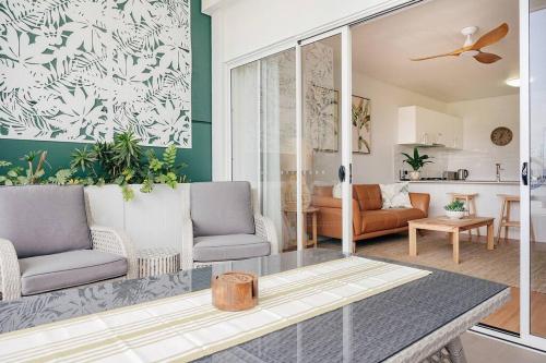 a living room with two chairs and a table at Stay Seaside Market St 116 in Woolgoolga