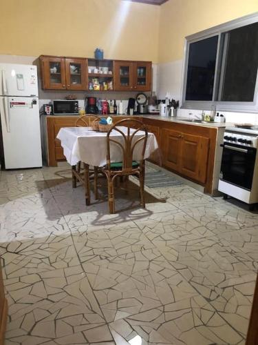 een keuken met een tafel en een witte koelkast bij Villa Dave Kribi in Kribi